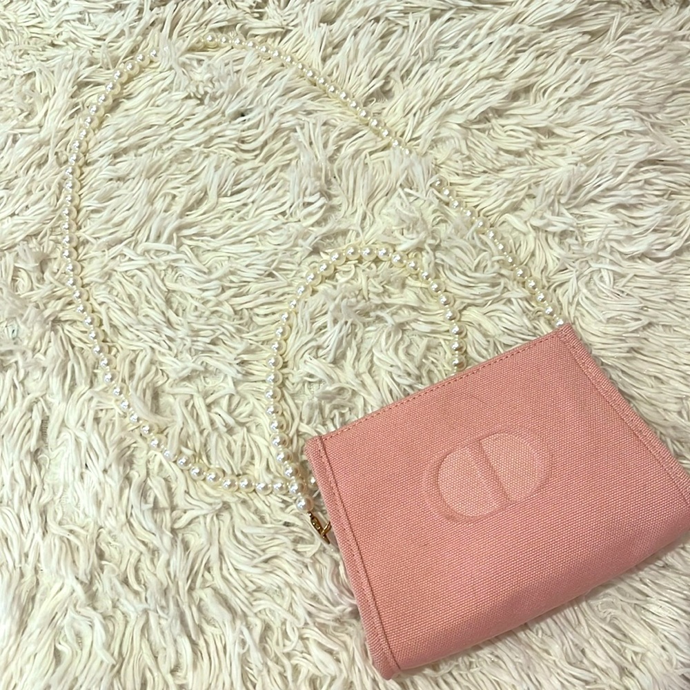 Pink Dior mini makeup bag with pearl strap